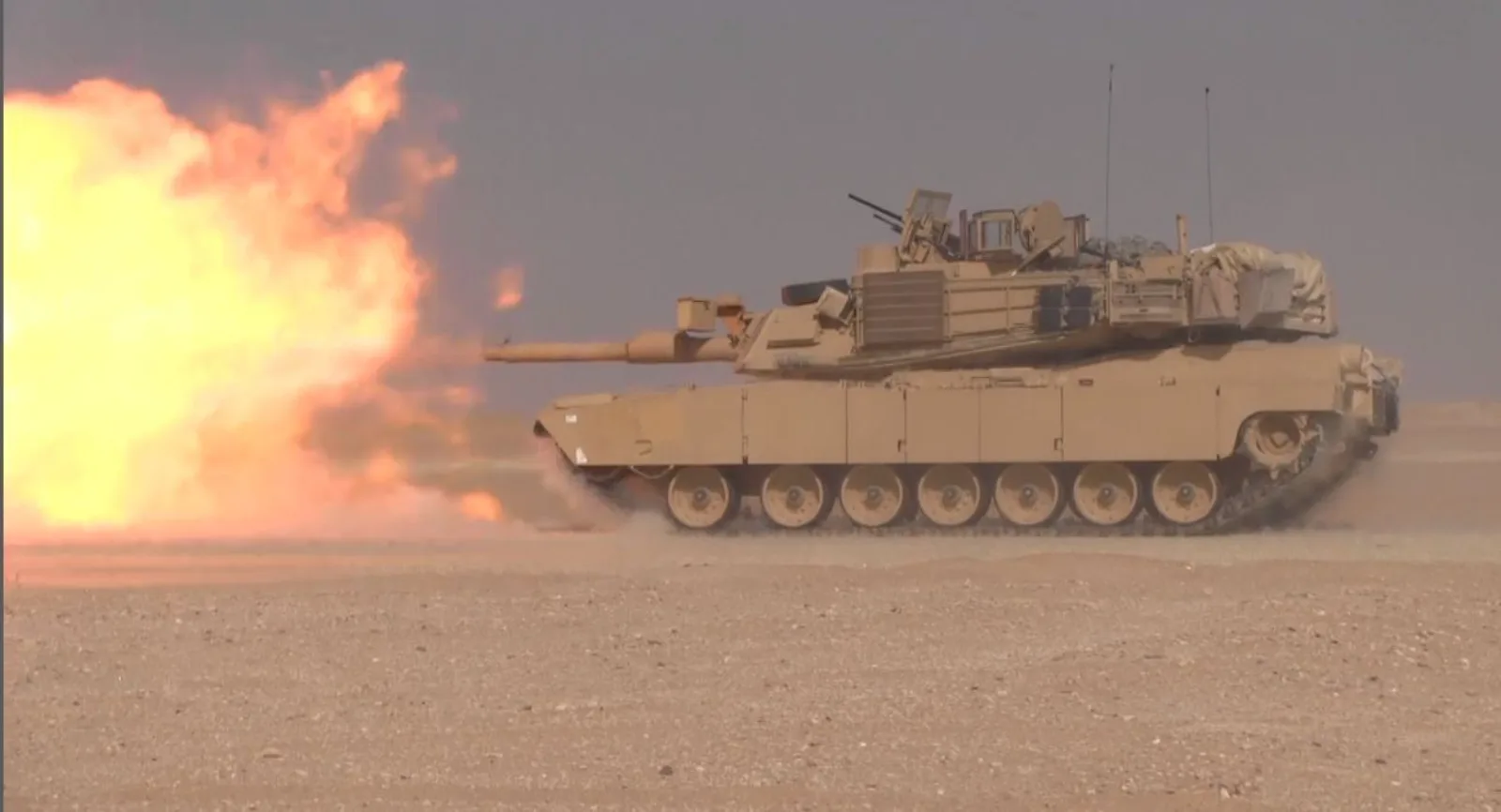 دبابة أبرامز M1A2 أمريكية تطلق مدفعها الرئيسي عيار 120مم أثناء الحركة خلال تدريب رمي حي في منطقة العديري قرب معسكر بحيرة بالكويت