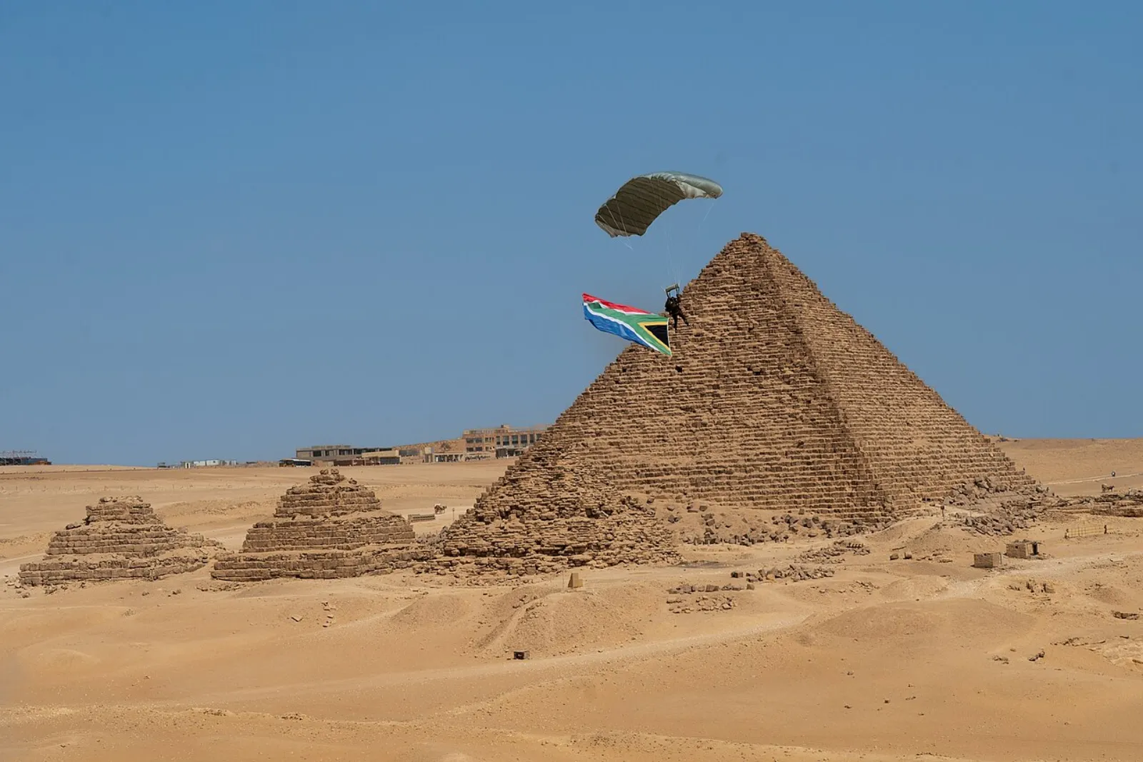 جنود من تحالف متعدد الجنسيات يقفزون قفزاً حراً عسكرياً فوق منطقة الأهرامات في مصر خلال تمرين النجم الساطع 2025