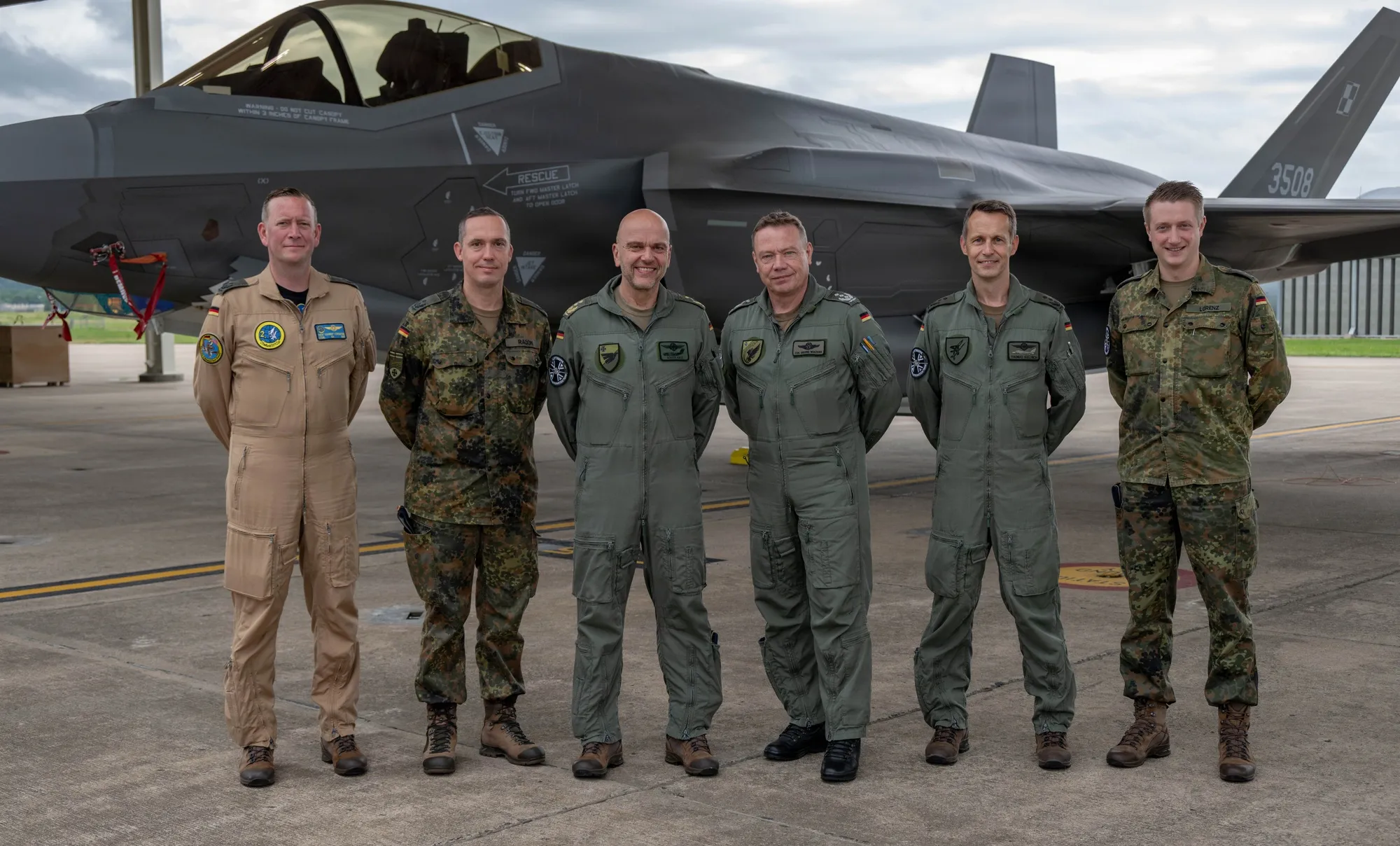 ضباط من سلاح الجو الألماني وضباط أمريكيون يقفون أمام مقاتلة F-35 خلال زيارة تعاون في قاعدة إيبينغ الجوية الوطنية بولاية أركنساس